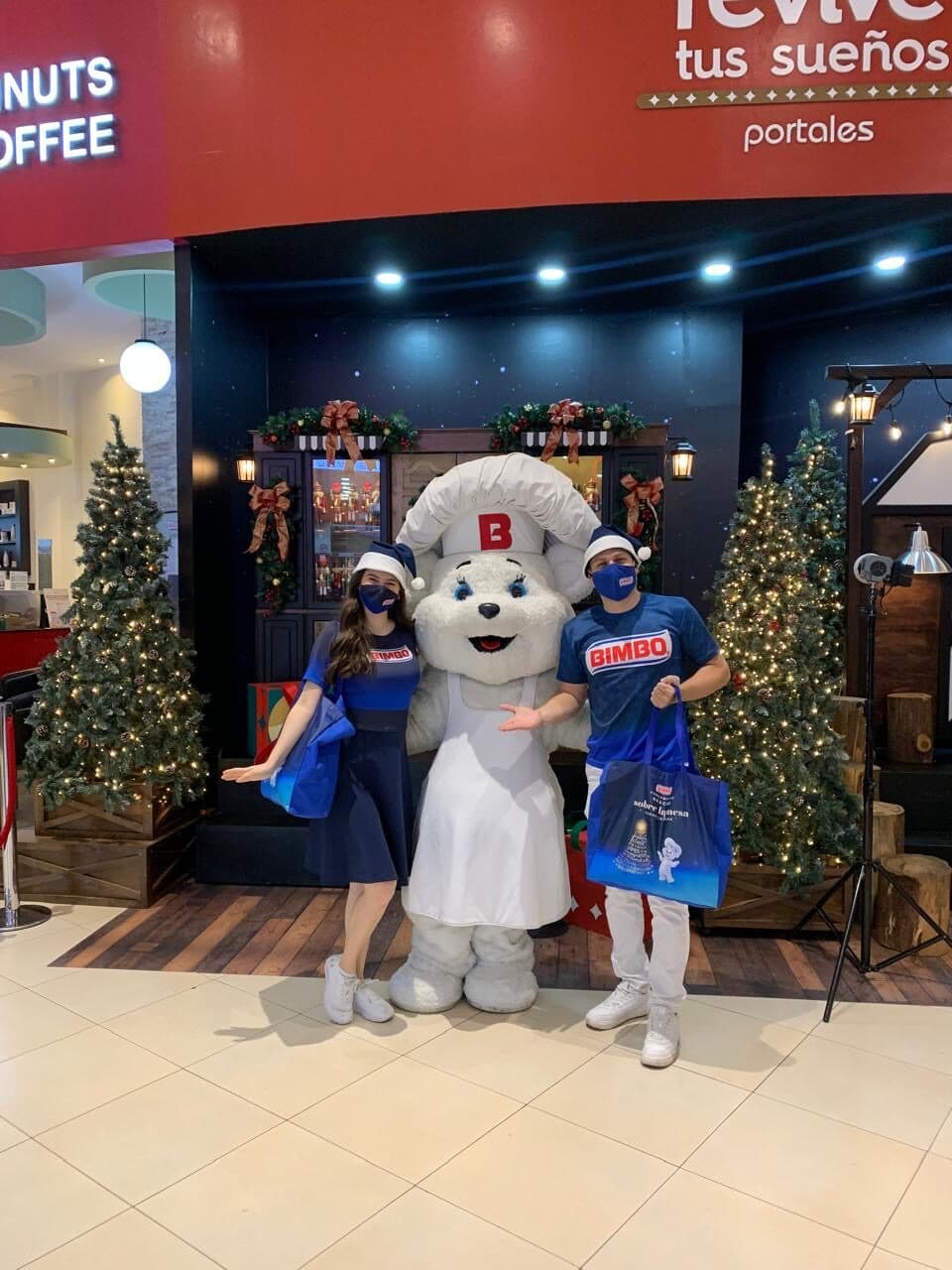 Equipo de activación navideña con la mascota de la marca en un centro comercial