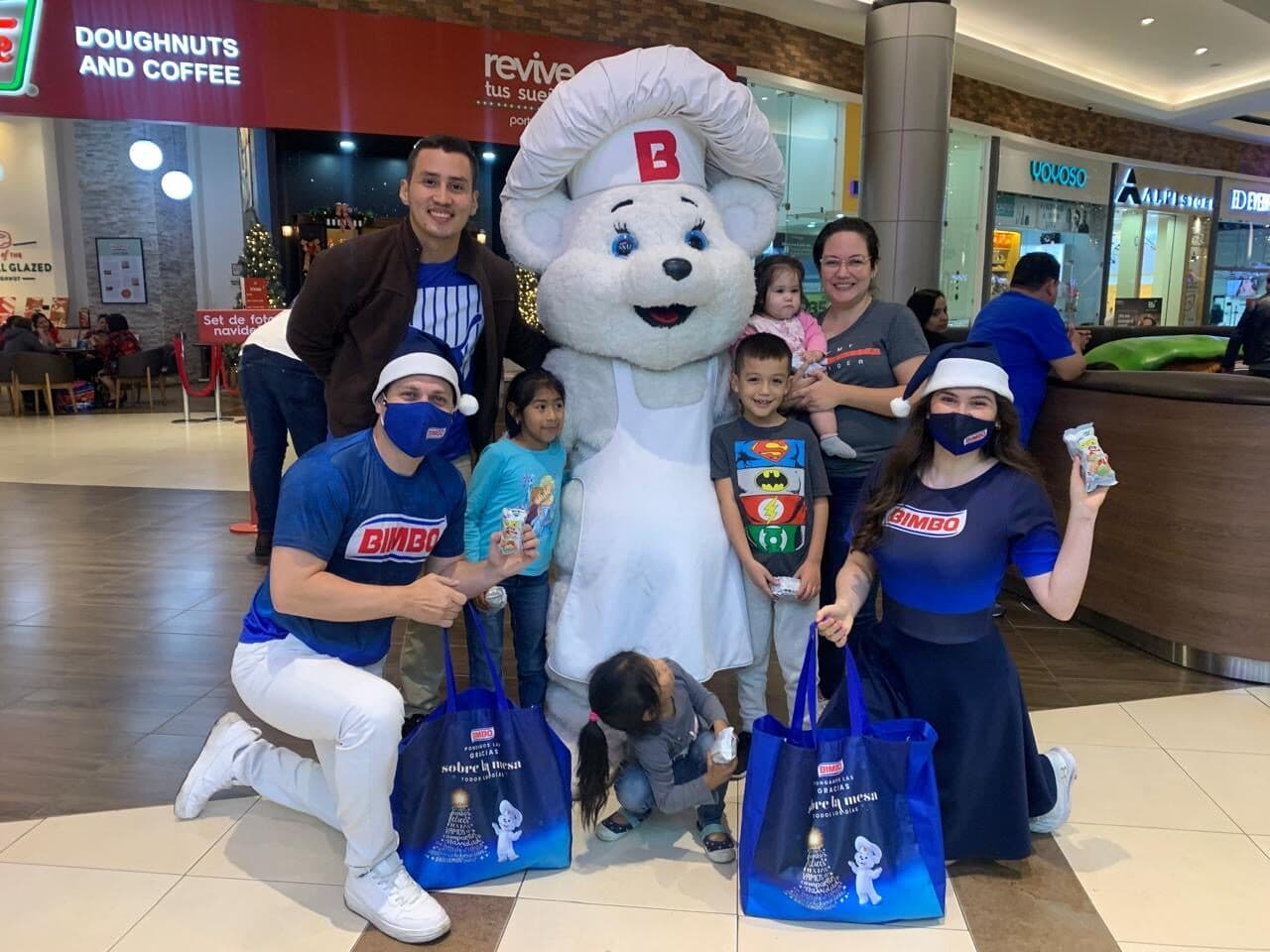 Mascota de marca compartiendo con una familia en una activación navideña